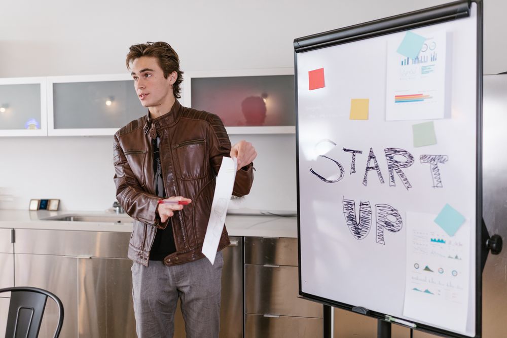 Ung entreprenör presenterar sin affärsidé vid ett blädderblock