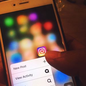 Ta bort oönskade annonser på Instagram (och andra sociala nätverk) Finger navigerar i Instagram-appen på en mobilskärm