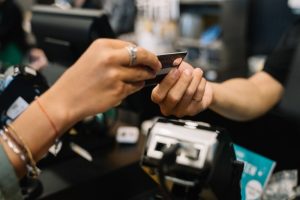 Kund betalar med kort i kassan i en butik