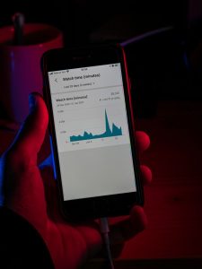 Hand håller en smartphone som visar ett statistikdiagram