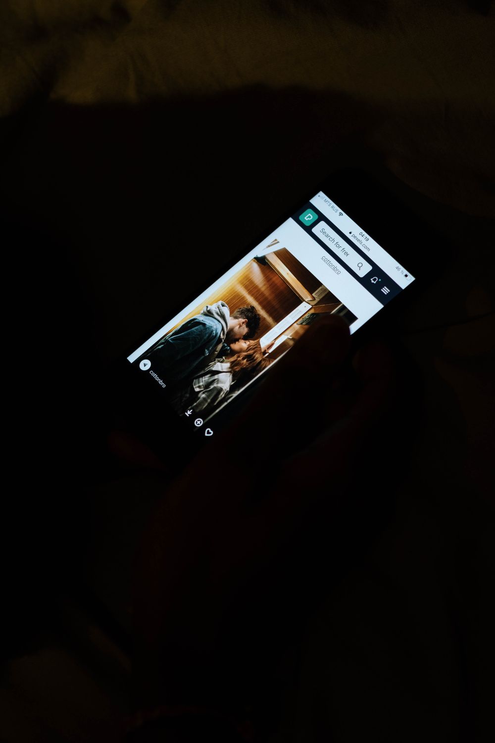 Smartphone i mörkt läge som visar ett socialt medie-flöde