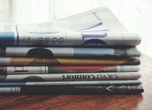 Här är medierna som visar fejksiffror på Ocast Trave med hopvikta dagstidningar på ett träbord