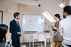 Är vi fast i komplexitetsfällan med våra IT-projekt? Kollegor diskuterar projektplanering kring diagram på en whiteboard