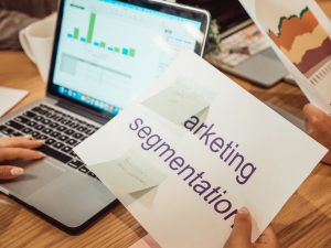 Enkel guide till digital marknadsföring Marknadsförare analyserar kampanjdata på laptop och pappersrapporter