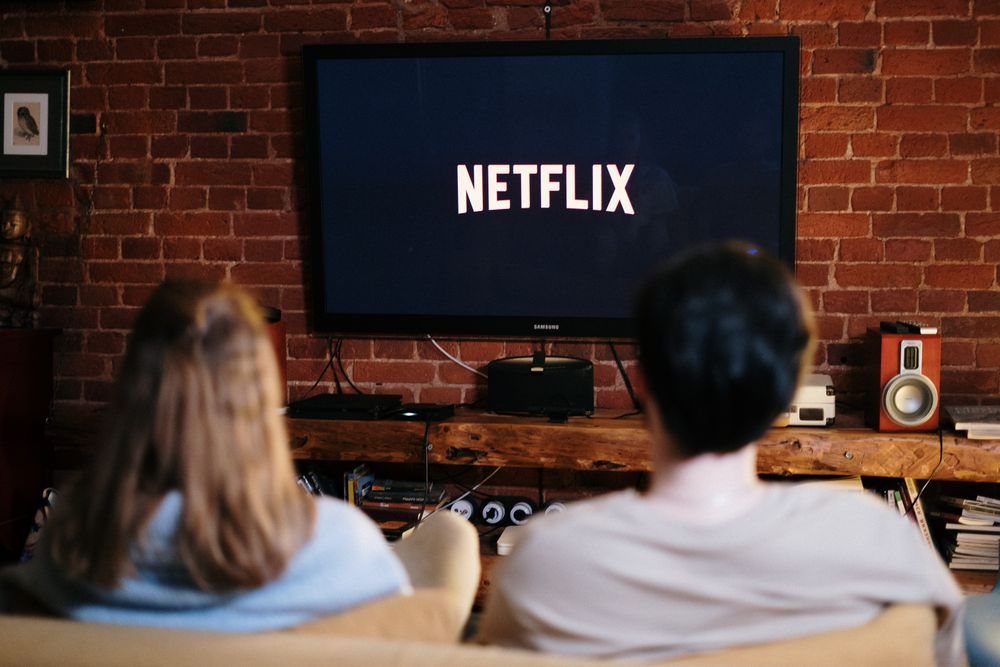 Par som ser på streamad tv i ett vardagsrum