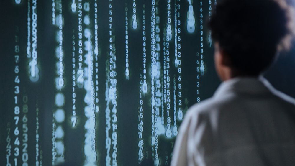 Person betraktar lysande siffror på en skärm, symbol för datadriven AI