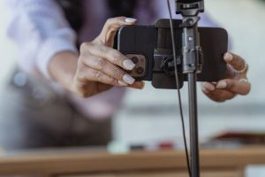 Vad betyder POV? Så används förkortningen på TikTok och Instagram Person ställer in mobiltelefon på stativ för att spela in en video, ett vanligt POV-klipp på TikTok och Instagram
