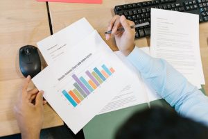 Är du redo att bli en insight professional? En analytiker granskar ett färgglatt stapeldiagram och dokument vid ett skrivbord