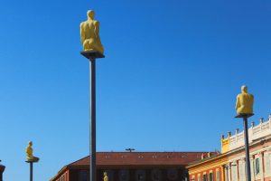 Bilder på offentlig konst – del två Gula skulpturer på stolpar på ett torg mot en klarblå himmel